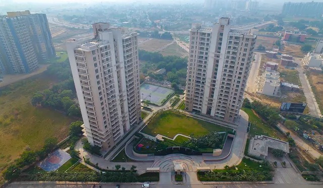 Alpha Gurgaon One — aerial of towers and central green (real photo)