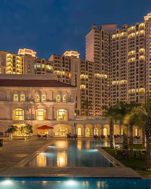 DLF Regal Gardens — clubhouse and pool with towers at dusk (real photo)
