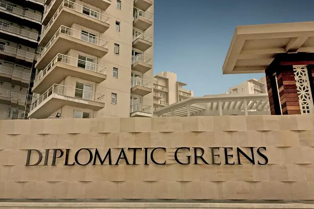Puri Diplomatic Greens — entrance signage with towers (real photo)