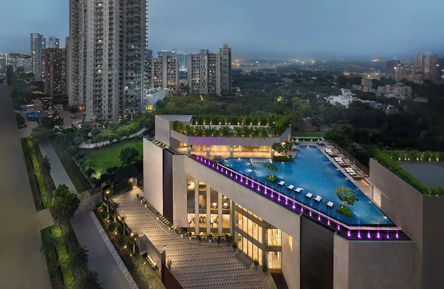 Puri Diplomatic Residences — clubhouse with infinity pool, aerial at dusk (real photo)