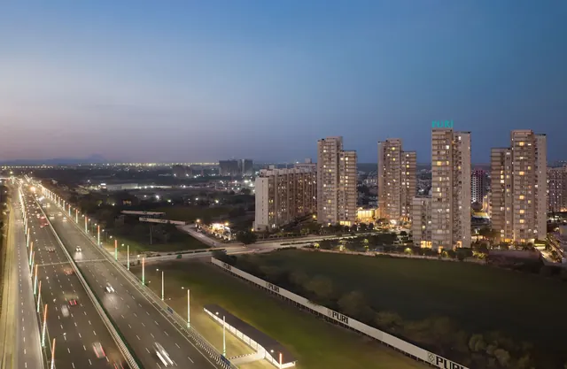 Puri Diplomatic Residences — towers and Dwarka Expressway at dusk (real photo)